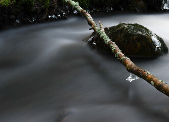 Rapidly flowing water in a stream in the nature in Finland in winter