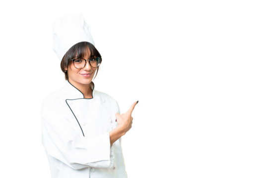 Young caucasian chef  woman over isolated chroma key background pointing back