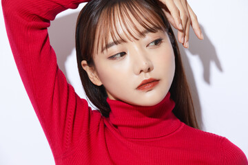 赤いニットを着た若い女性のビューティー ポートレート