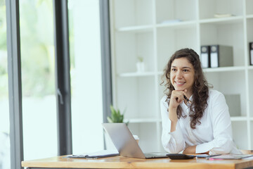 Fototapeta na wymiar Businesswoman using laptop sitting at desk in office. Digital marketing concept.