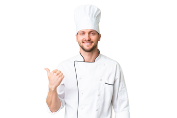 Young caucasian chef over isolated chroma key background pointing to the side to present a product