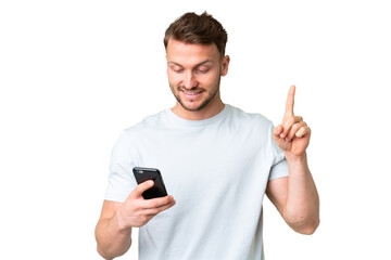 Young handsome caucasian man over isolated chroma key background using mobile phone and lifting finger