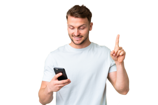 Young handsome caucasian man over isolated chroma key background using mobile phone and lifting finger