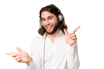Telemarketer man working with a headset over isolated chroma key background pointing finger to the laterals and happy