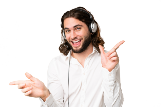 Telemarketer man working with a headset over isolated chroma key background pointing finger to the laterals and happy