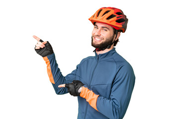 Young cyclist man over isolated chroma key background pointing finger to the side and presenting a product - obrazy, fototapety, plakaty