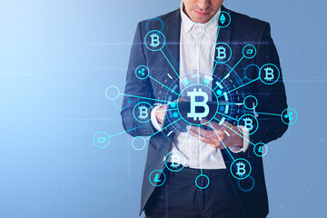 Businessman with tablet, bitcoin hologram icons and blockchain
