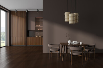 Brown kitchen interior with eating table and cooking area near panoramic window