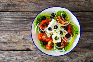 Fresh vegetable salad with feta cheese on wooden table
