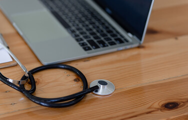 Doctor stethoscope on laptop at desk, healthcare and medical concept.	