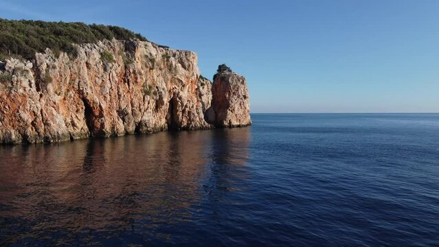 A man on a SUP board swims up to a uninhabited island in the Mediterranean Sea. Uc adalar islands. 