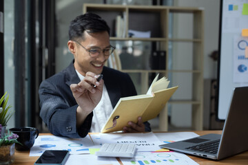 Happy Asian man working online sitting at desk in office, freelance business, Asian man happy and smile face.