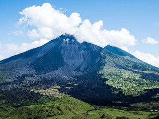 view of the volcano between clouds and a meadow