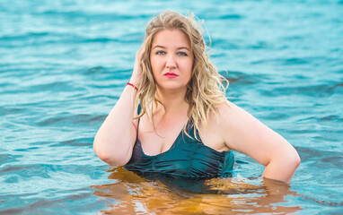 Plus size woman in water in swimsuit. Chubby nice lady, body positive concept, different women sizes