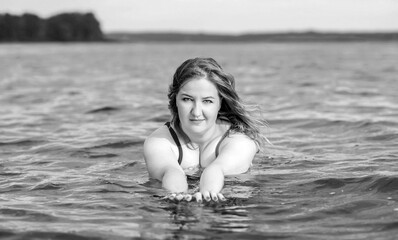 Fototapeta premium Plus size woman in water in swimsuit. Chubby nice lady, body positive concept, different women sizes