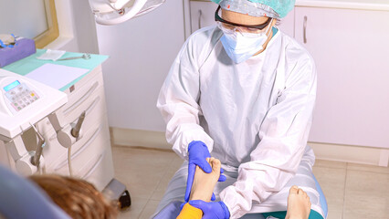Female podiatrist doing chiropody in her podiatry clinic. Selective focus