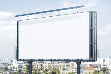 Obraz premium Blank white horizontal billboard on city buildings background at daytime, perspective view. Mockup, advertising concept