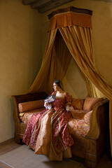 Renaissance lady sitting on antique bed © Anneke
