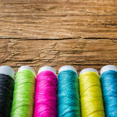 colored thread on a wooden background
