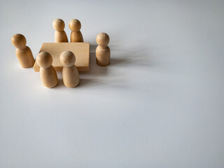 Wooden people figures having business meeting with customizable space for text. Business concept and copy space.