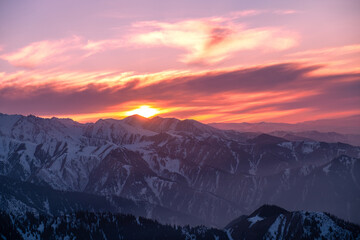 Amazing mountain view in the last rays of the setting sun; snow covered mountain ranges at sunset