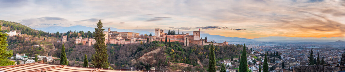 Fototapeta na wymiar Panoramic of the Alhambra, Palace of Carlos V, Sierra Nevada and the city of Granada, from the viewpoint of San Nicolas at sunset.