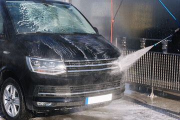 Worker cleaning car using high pressure water. Self servise car washing. Clean auto