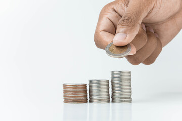 hand putting a coin on stacks of coin, money saving concept, financial and business growth concept, white background, copy space.