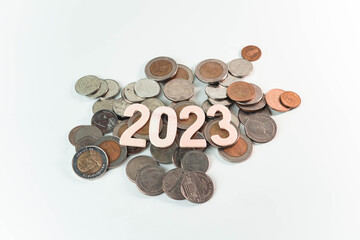 Wooden text of 2023 on pile of money, money saving concept, financial and business growth, white background