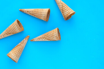 Empty ice cream cone on blue background.
