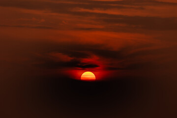 Beautiful half sun set in the middle of the cloud. Magical moment at the sky. Giant orange sunrise red sky and cloud move silhouette.