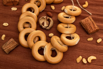 A bundle of bagels on a thread, lying on brown corrugated paper. Baking for dessert