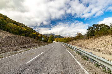 The road to the mountains. Highway running away into the distance on a sunny day in the mountains. The road to the Bezengi gorge. The nature of Russia.