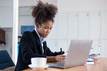 Young African American businesswoman working on laptop with documents and stressed over worked from work in the office, Overworked woman concept.