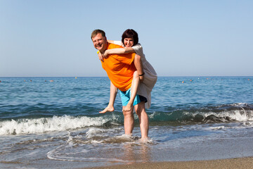 Happy adult couple tourists from Europe on the beach.