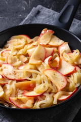 fried onion and red apple slices on skillet