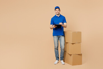 Full body delivery guy employee man wear blue cap t-shirt uniform workwear work dealer courier...