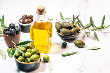 Mixed types of olive in the bowls and olive oil on a light background, banner, menu, recipe place...