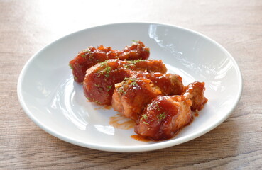 crispy fried chicken drum wing dressing tomato sauce and topping oregano on plate