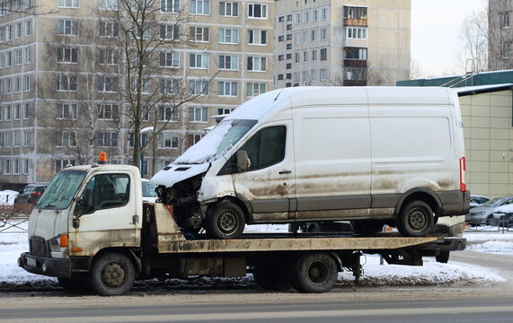 A tow truck transports a broken white minibus for repair, Iskrovsky Prospekt, St. Petersburg, Russia, February 2023