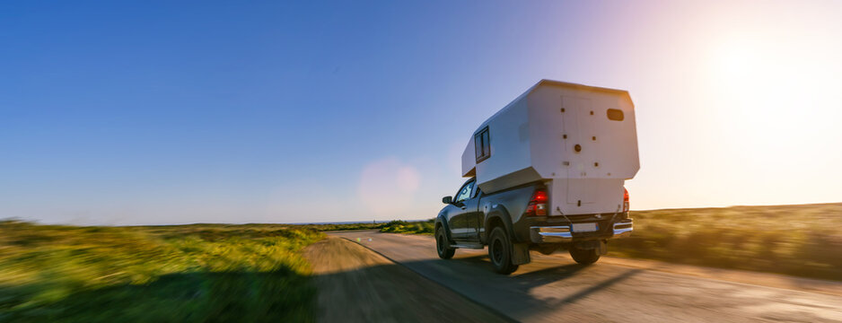 expedition camping van pick up truck on a dirt road on a sunny afternoon