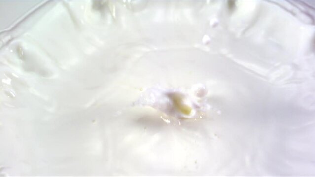 Integration of lemon with milk. Artistic footage of lemon falling into milk in slow motion.