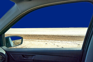 View from the car window over a large salt lake in Tunisia, sky replaced with dark blue background...