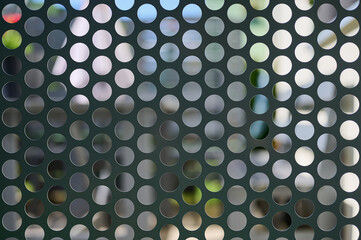 abstract background of a metal grid with round holes in the center