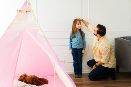 Dad measuring the height of her daughter at home