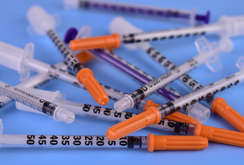 A lot of insulin syringes on a blue background.Close-up.

