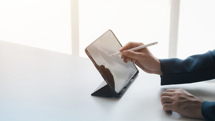 Business men are looking at the company's financial documents on tablets to analyze problems and find solutions before bringing the information to a meeting with a partner. Financial concept.