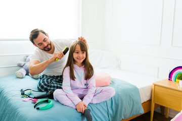 Caucasian father brushing his daughter's hair