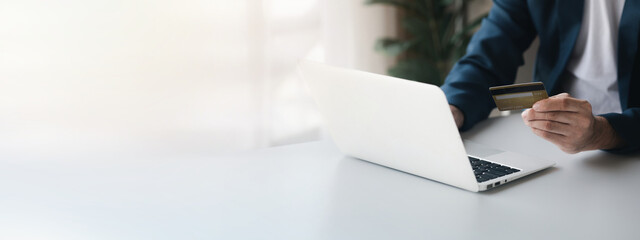 Person holding a credit card, uses a credit card to pay for goods and services online, the concept...