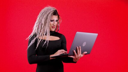 Happy transgender person standing and using a laptop - Powered by Adobe